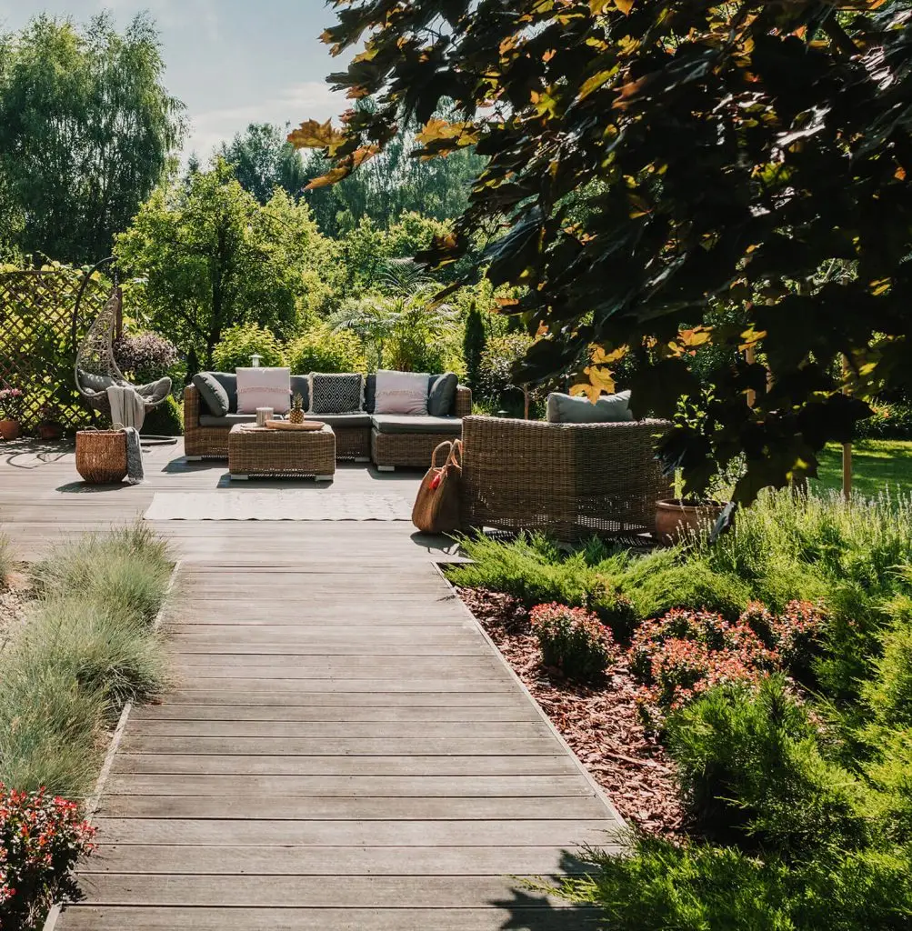 Chemin en bois menant à une terrasse de jardin avec mobilier moderne et décoration tendance fait par DG Paysageet Piscine à Dinan